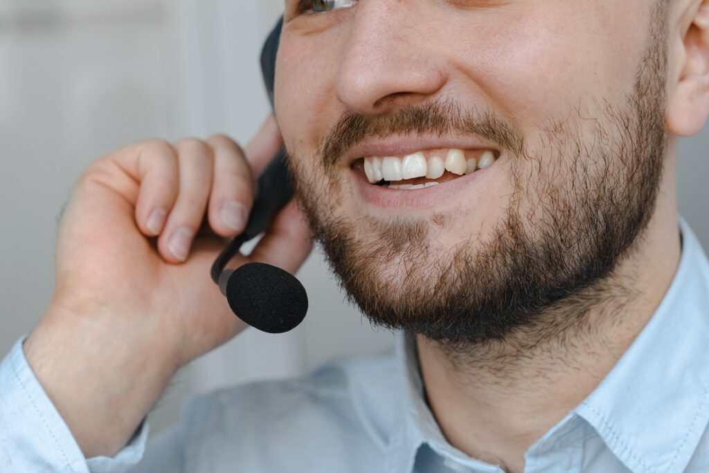 Un homme de standard téléphonique souriant. Vitaris