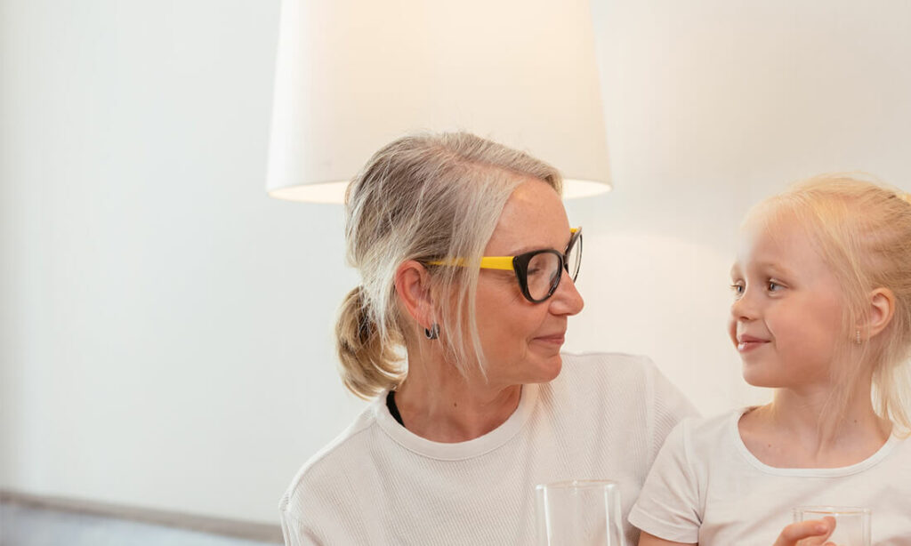 Une baby-sitter et une jeune fille se regarde dans les yeux en souriant