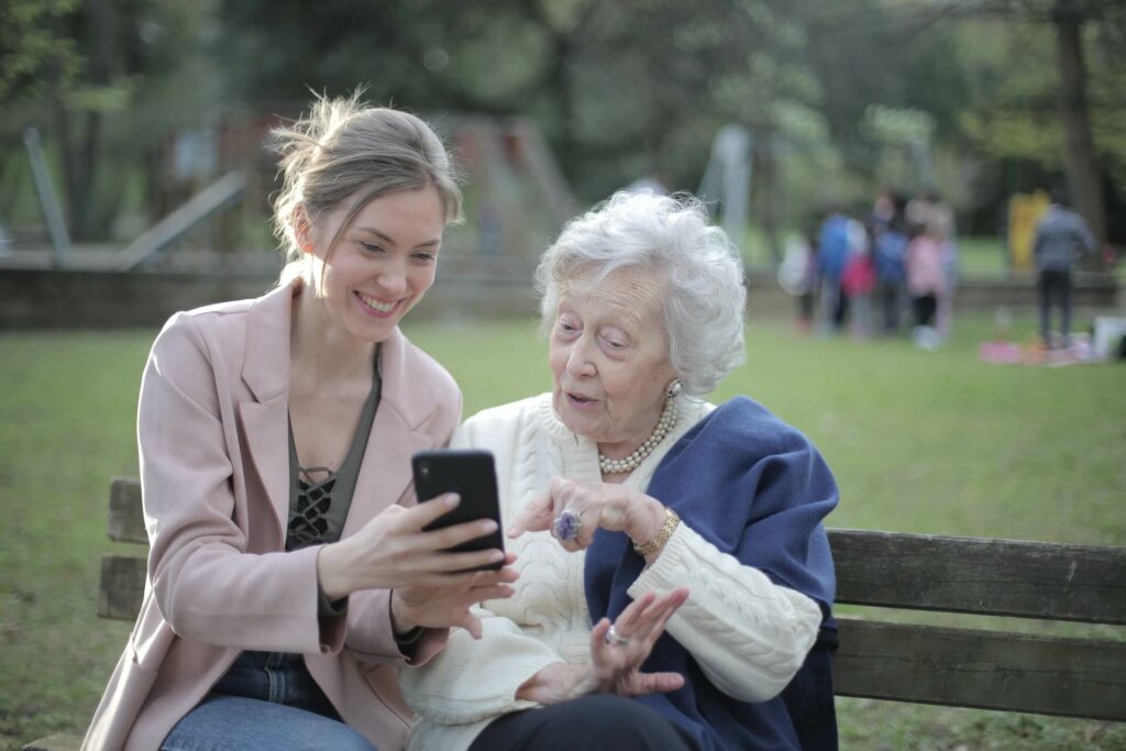 Femme senior regarde le smartphone d'une jeune femme