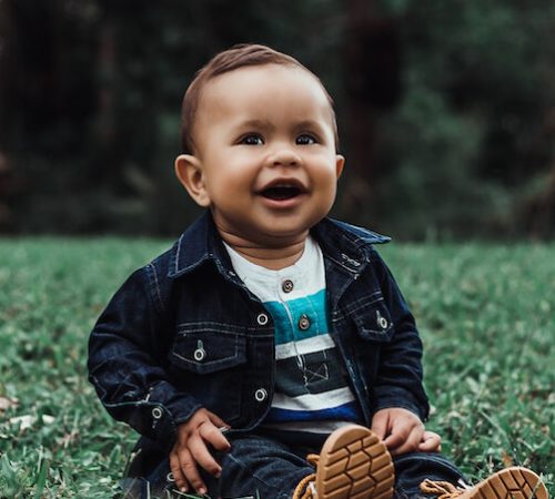 Bébé assis dans l'herbe et rigolant