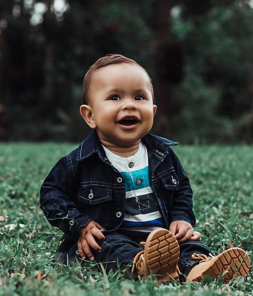 Bébé assis dans l'herbe et rigolant