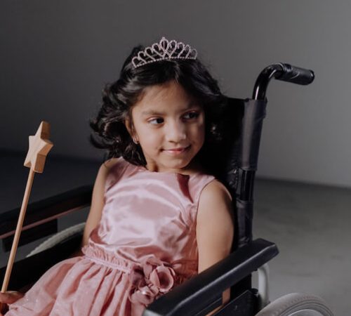 Fillette dans un fauteuil roulant déguisée en princesse