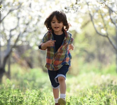 Enfant court dans un jardin